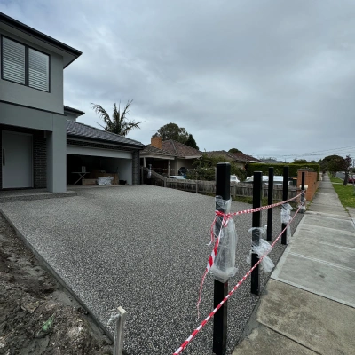 Exposed aggregate driveway beside a modern home
