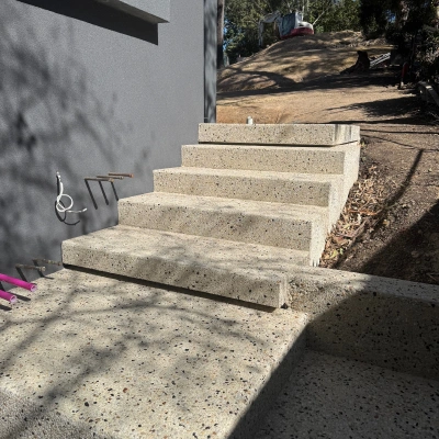 Exposed aggregate steps against a dark modern wall