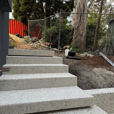 Exposed aggregate steps rising through a landscaped site